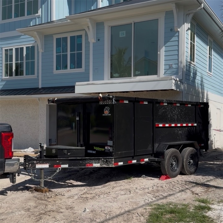 Dump trailer hitched to the truck in front of a new home under construction